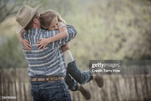 Caucasian father lifting and hugging daughter
