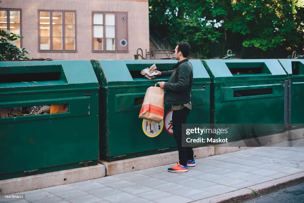 Full length of man throwing garbage in can