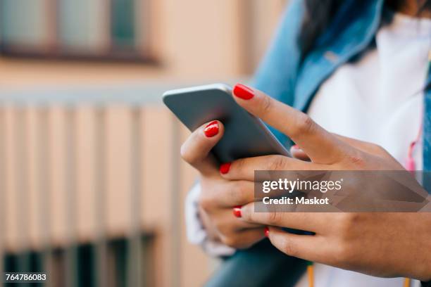 cropped image of teenage girl using mobile phone - draagbaarheid stockfoto's en -beelden