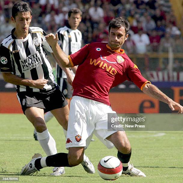 Mirko Vucinic of Roma and Paul Codrea of Siena battle for the ball during a Serie A match between Roma and Siena at the Stadio Olimpico on September...