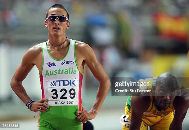 Sean Wroe of Australia stands next to Michael Blackwood of Jamaica as they wait for the results of their semi final heat the Men's 400m during day...