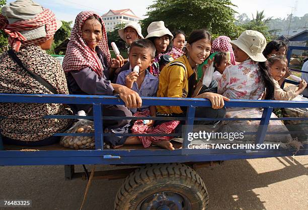 Cambodia-KRouge-economy-gambling-tourism,FEATURE" by Suy Se Passengers smile as they travel on a trailer, in the former Khmer Rouge's stronghold...