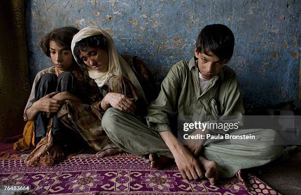 Sabera sits along side her children Zaher and Gulparai August 27, 2007 in Kabul, Afghanistan. Sabera, a widow, has been smoking for four years since...