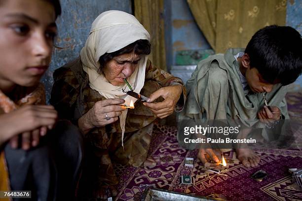 Sabera smokes heroin along side her children Zaher and Gulparai August 27, 2007 in Kabul, Afghanistan. Sabera, a widow, has been smoking for four...