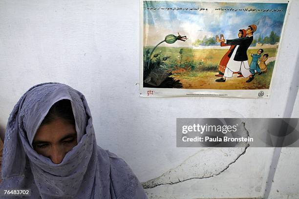 Former drug addict stands near an anti drug poster during her month long detox program at the Sanga Amaj Drug Treatment Center August 28, 2007 in...