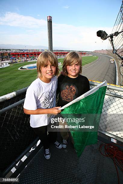 Actors Cole and Dylan Sprouse pose in the flag stand prior to the start of the NASCAR Nextel Cup Series Sharp Aquos 500 at California Speedway on...