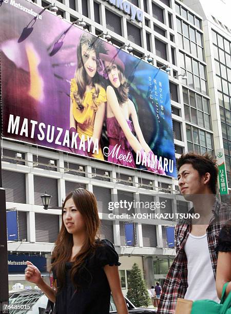 Pedestrians pass before a Matsuzakaya department store in Tokyo's Ginza shopping district, 03 September 2007. Matsuzakaya and Daimaru department...