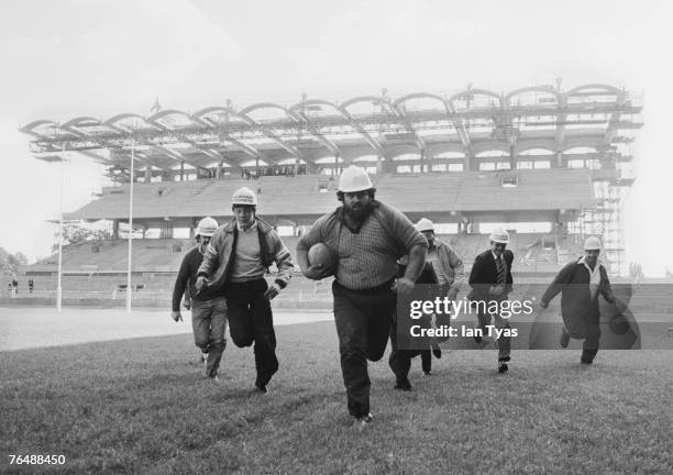 Construction workers playing rugby after the topping out ceremony to mark the completion of the South Stand at Twickenham Stadium, west London, 13th...