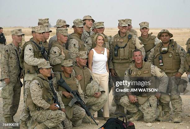 Newly appointed White House Press Secretary Dana Perino poses with US Marines as US President George W. Bush tours Al-Asad Air Base in Anbar...