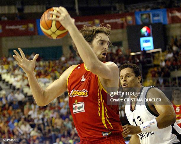 Spain's Pau Gasol is watched by Portugal's Elvis Evora during a preliminary round match of the European basketball championships at the Pabellon de...