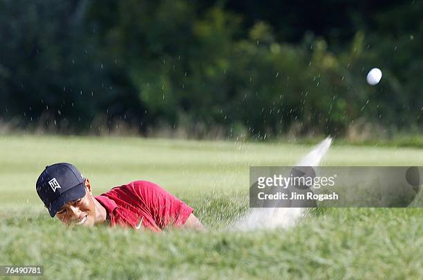 Tiger Woods hits out of a bunker toward the ninth green during the fourth and final round of Deutsche Bank Championship, the second event of the new...