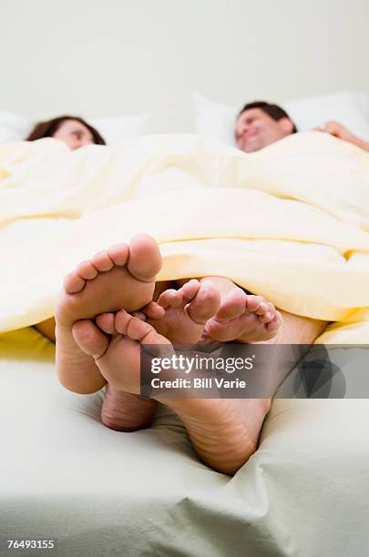playing footsie in bed - playing footsie stock pictures, royalty-free photos & images