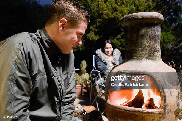 couple relaxing near outdoor fire - hot latin nights stock pictures, royalty-free photos & images