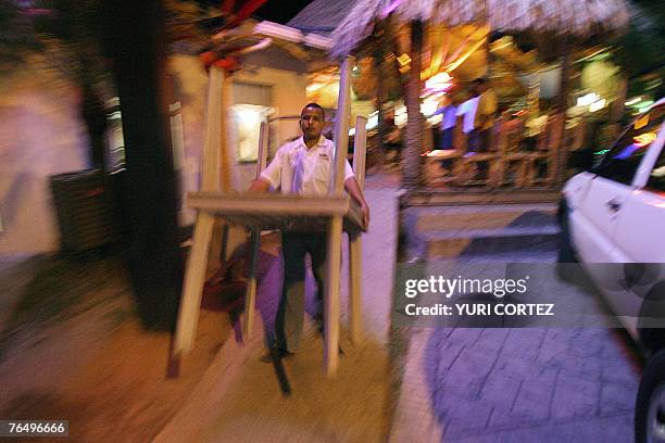 An employee of a restaurant near the beach prepares to close the place as Hurricane Felix approaches in La Ceiba, 03 September 2007. Honduras and...