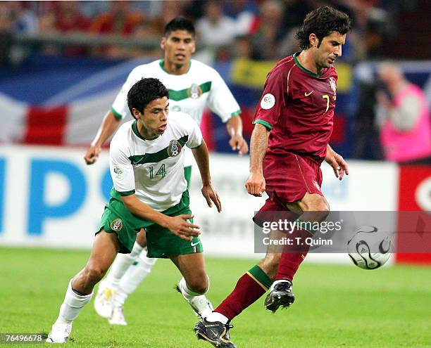 Luis Figa controls the ball in front of Gonzalo Pineda during the Group D match between Portugal and Mexico at FIFA World Cup stadium Gelsenkirchen,...