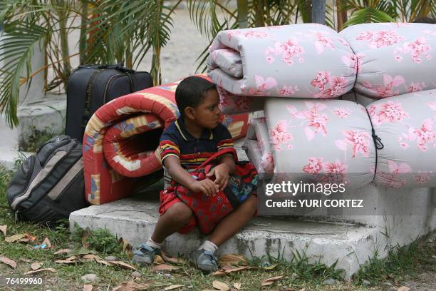 Boy awaits for his father as they arrive at a temporary shelter in the city port of La Ceiba, Honduras, as hurricane Felix approaches 04 September...