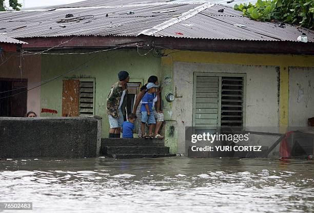 Family observe from their house a flooded street during heavy rains in the city port of La Ceiba, Honduras as hurricane Felix approaches 04 September...