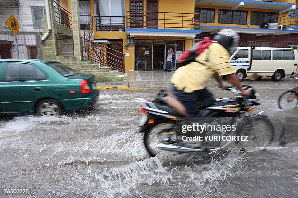 Man rides his motorcycle in a flooded street of the city port of La Ceiba, Honduras as hurricane Felix approaches 04 September 2007. As the hurricane...