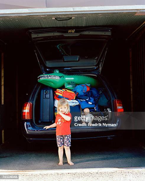 a girl in front of a crammed car. - bulges stock pictures, royalty-free photos & images