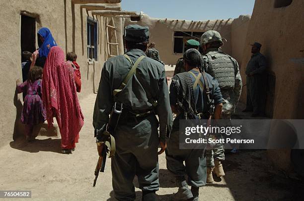 Women gather in a single room and keep out of sight, as the Afghan National Police, backed up by US Army's 82nd Airborne Division, search houses for...