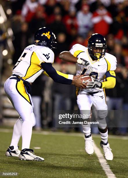 Patrick White quarterback for the University of West Virginia hands off to Steve Slanton tailback against the University of Louisville at Papa John's...