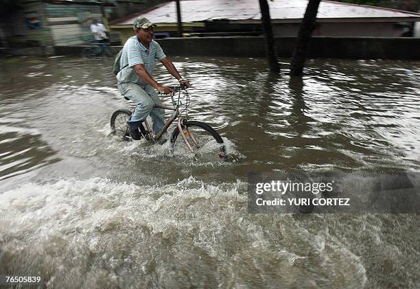 Man rides his bike in a flooded street of the city port of La Ceiba, Honduras as hurricane Felix approaches 04 September 2007. As Hurricane Felix...