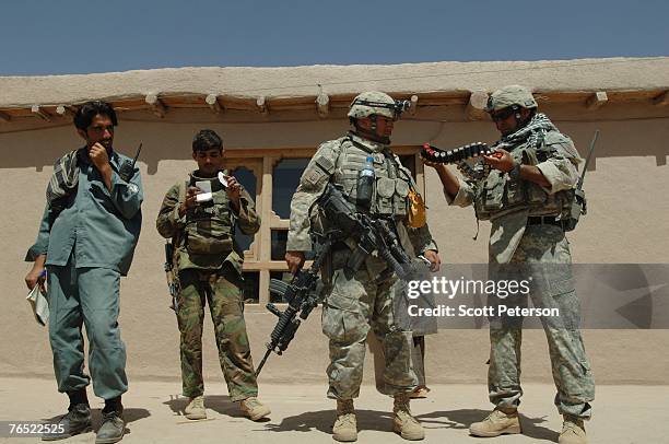 Soldiers examine shotgun shells, as the Afghan National Police, backed up by US Army's 82nd Airborne Division, search houses for unauthorized weapons...
