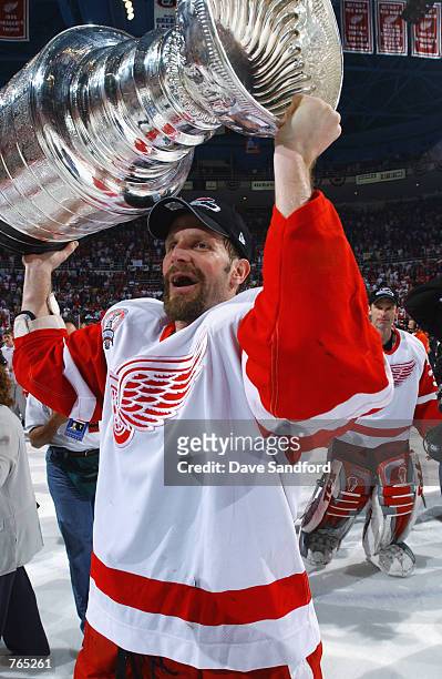 Steve Duchesne of the Detroit Red Wings raises the Stanley Cup after defeating the Carolina Hurricanes during game five of the NHL Stanley Cup Finals...