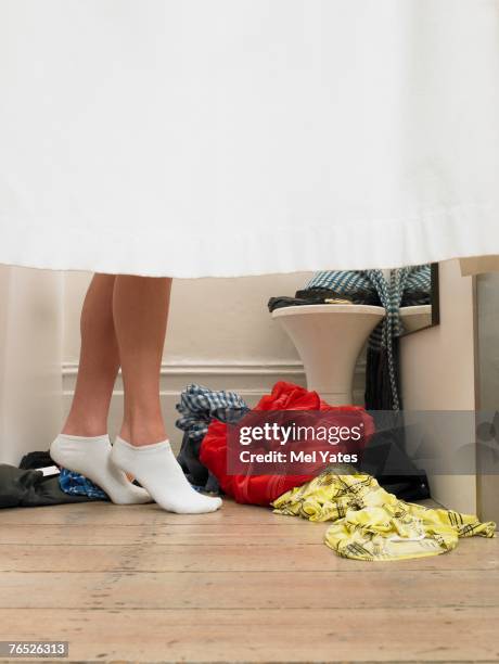 woman standing behind curtain in changing room, low section - fitting room stock pictures, royalty-free photos & images