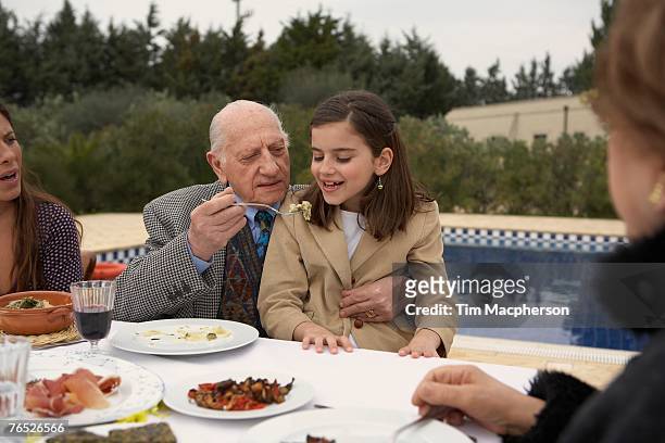 three generation family eating outdoors - italien familie stock-fotos und bilder