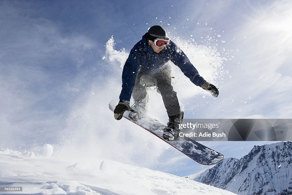 Male snowboarding on mountain, action shot