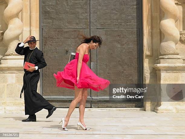 priest passing woman whose skirt is blowing up in the wind, alicante, spain, - bad habit fotografías e imágenes de stock