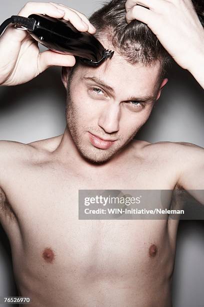 shirtless man shaving hair with electric razor, portrait - rasieren stock-fotos und bilder