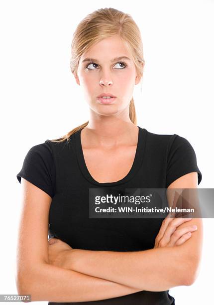 woman with her arms crossed looking up - taunts stock pictures, royalty-free photos & images