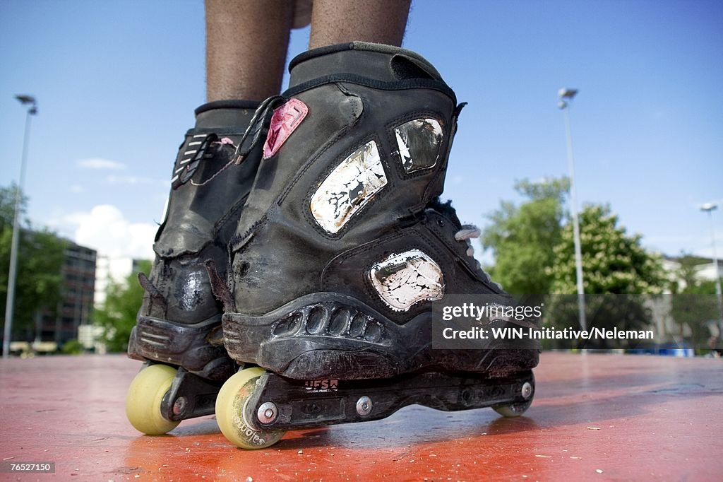Young man wearing inline skates, low section
