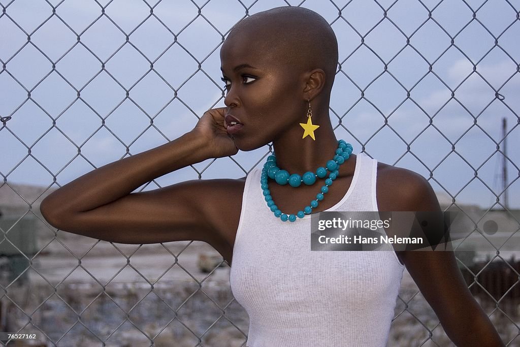 Young woman in white tank top looking away