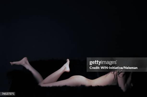 naked woman lying on front, side view - woman lying on stomach with feet up stock pictures, royalty-free photos & images