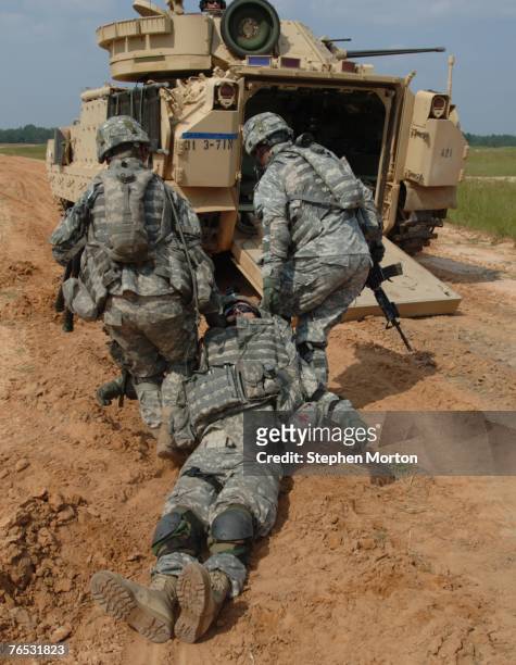 Members of the U.S. Army's 3rd Infantry Division, 4th Brigade Combat Team drag a mock wounded soldier to a Bradley Fighting Vehicle during a live...