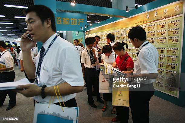 Salesmans promote second-hand houses to the visitors at the Beijing Autumn Real Estate Trade Fair on September 6, 2007 in Beijing, China. Beijing's...