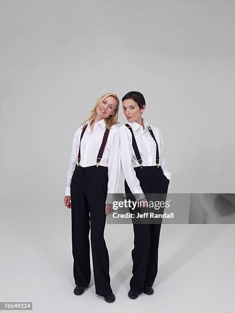 two mature women wearing trousers and braces, smiling - women in suspenders stock pictures, royalty-free photos & images