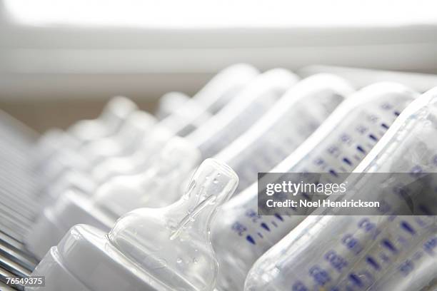 baby's bottles on drying rack, close-up - baby bottle stock pictures, royalty-free photos & images