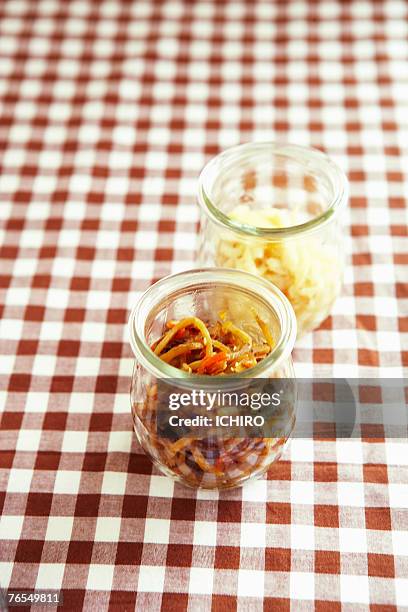 two glass jars containing cooked vegetables on checked table cloth - lohas stock pictures, royalty-free photos & images