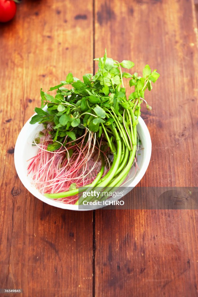 Bowl of herbs on wooden table