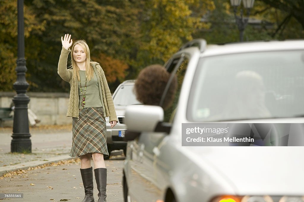 Girl standing in street, waving hand