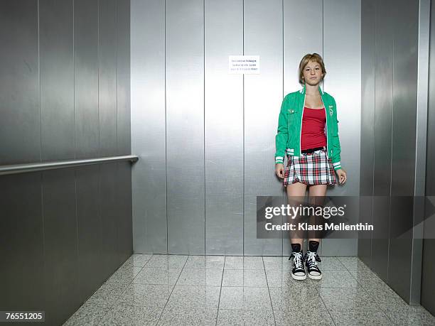 young woman standing in lift - ascenseur interieur photos et images de collection