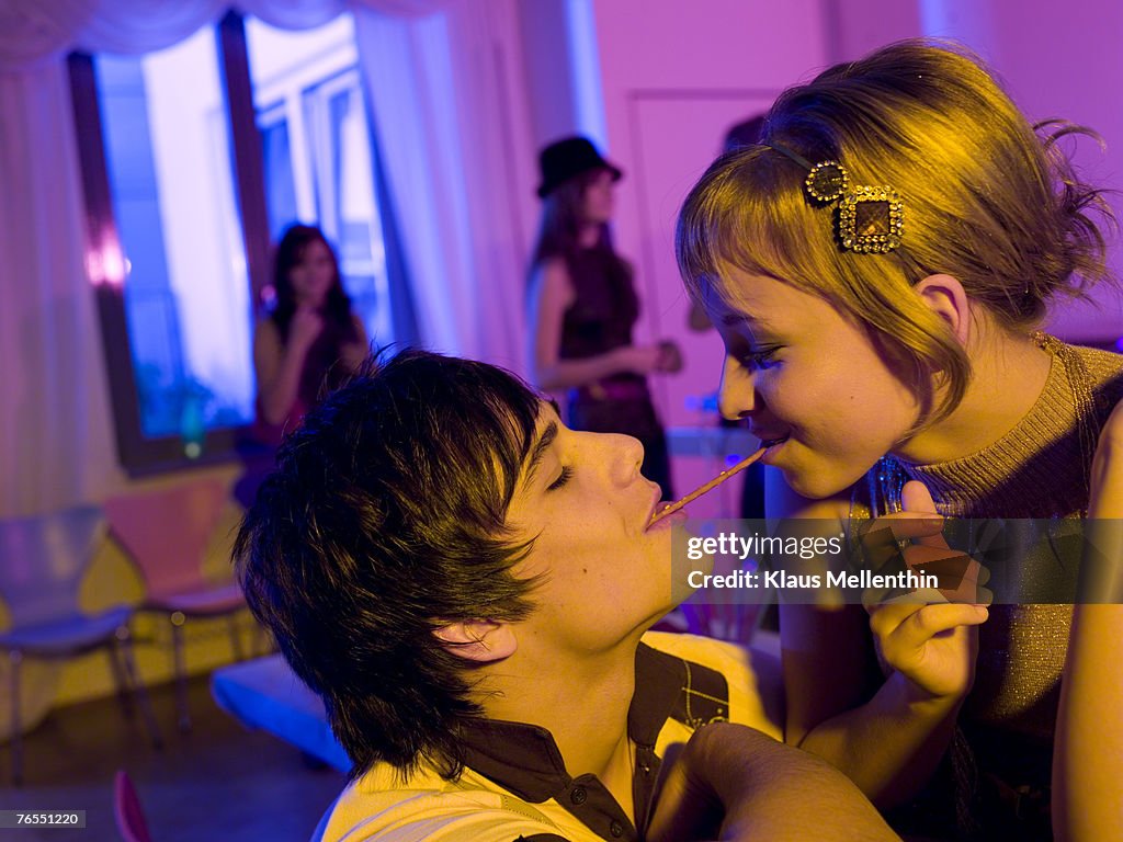 Young couple on party with pretzel sticks