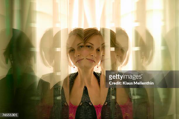young woman reflected in glass panes - ripetizione foto e immagini stock