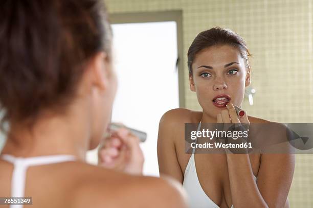 young woman applying lip-stick - woman lipstick rearview stock-fotos und bilder