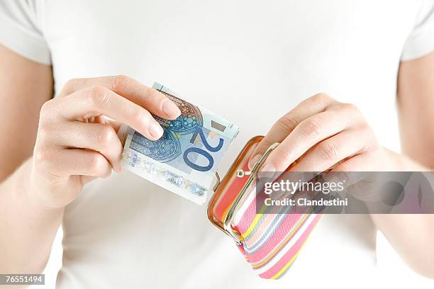 woman putting money in change purse, close-up - nota de euro da união europeia imagens e fotografias de stock