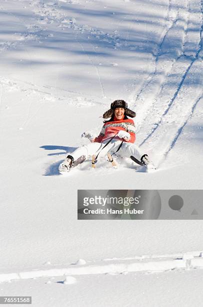 woman tobogganing in mountains - wintersport stock-fotos und bilder